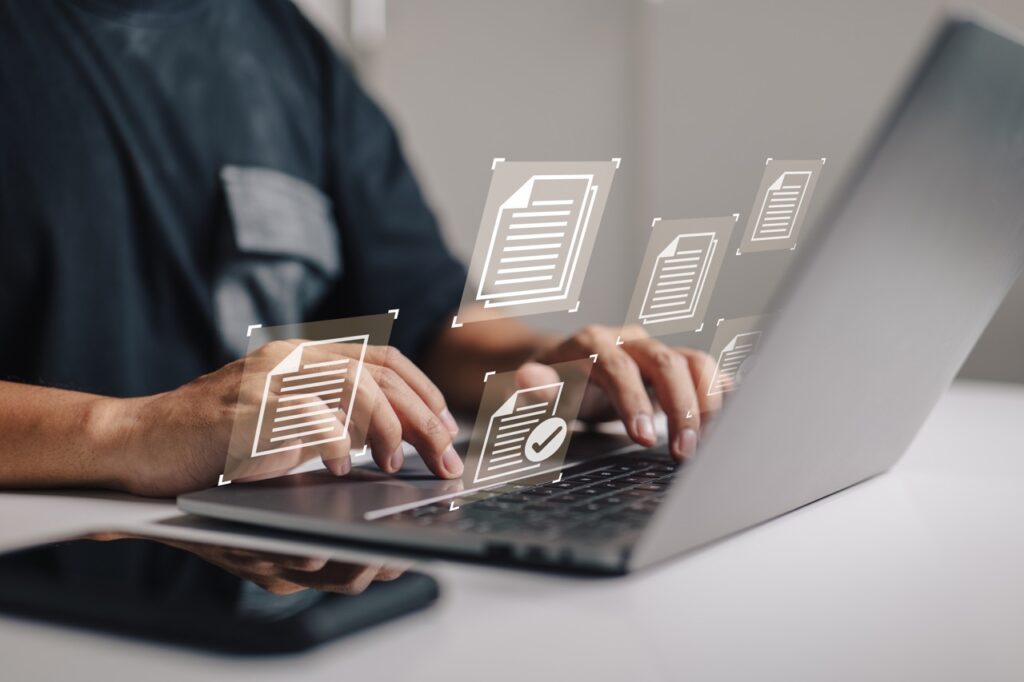 document management data system business internet technology concept of a businessman hand using a laptop computer with a document management icon.